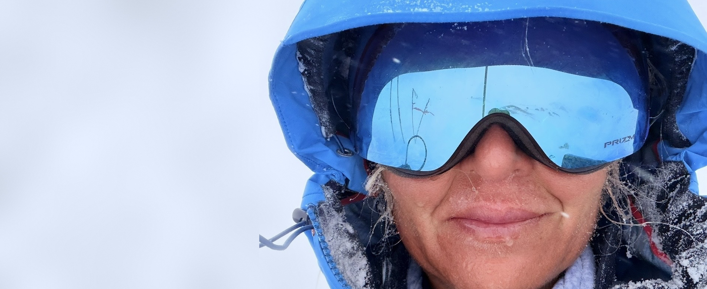 Erica Stanford in mirrored ski goggles and a blue hood, frost on her face, during polar training