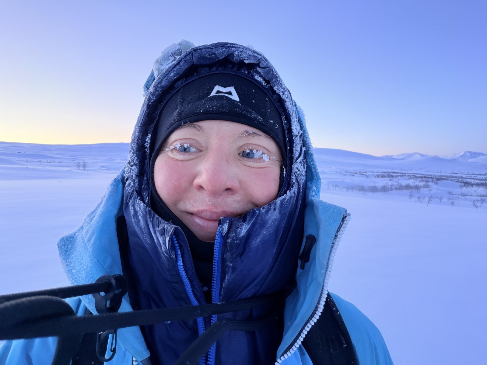 Erica Stanford in a polar down jacket with frost on her face during polar training in Arctic Finland