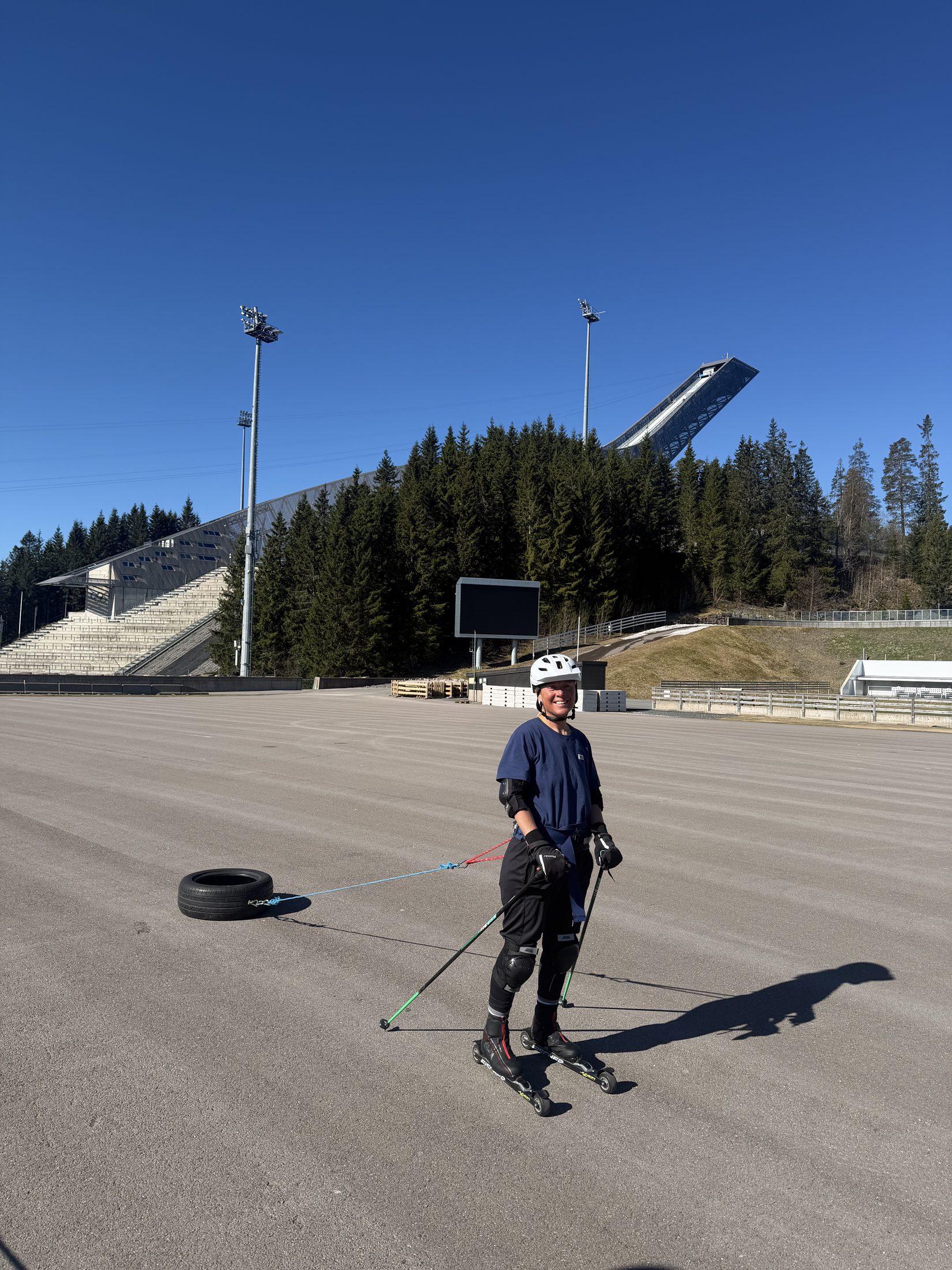 Erica Stanford roller skiing on the track at Holmenkollen in Oslo, the ski jump behind